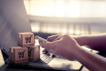 Online delivery service concept.Young business working sitting using smartphone at desktop computer...