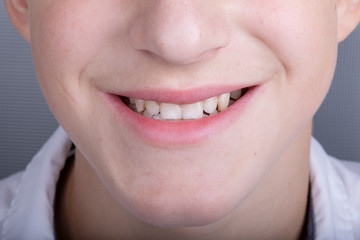 Face of a young guy with a smile and teeth, close-up