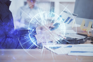 Double exposure of businessman working on laptop on background. International business hologram in front. Concept of success.