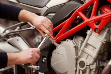  Technician hands repairing motobike, doing repair service, maintenance worker repairing vehicle with wrench, service and maintenance motocycle check    