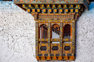 bhutanese painted window on white brick wall