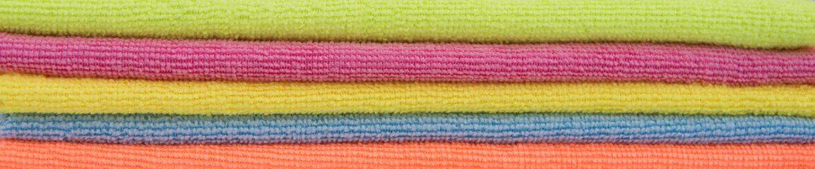 Multi-color folded fresh clean image of towels, microfiber cloth, cleaning cloths. Banner background.