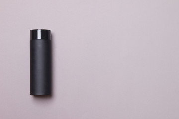 black thermos cup on grey background with copy space