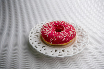Pink Doughnut in a Vintage White Plate on a White Bakground