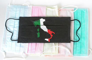 Black medical mask with picture of Italian Flag in Map Shape. Black medical mask is a symbol of mortal danger of coronavirus in Italy. Close up protective masks textile filter.