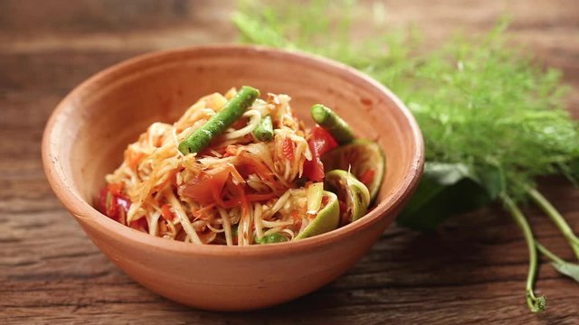 Thai food: Som Tam is popular Thai food. Papaya salad with dried shrimp, salty crab, chili, tomato and spicy herbs. Served with vegetables. Still life shoot in studio, Clean food good taste concept.