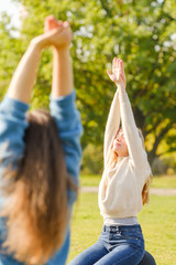 Obraz premium A group of young people meditate outdoors in a park. 