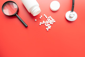 Medical, medicine stethoscope and pills on red background. Health care or illness. Tablet or drug...
