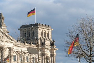 Obraz premium German flag fluttering outside the Berlin Bundestag Reichstag or Bundestag, seat of the German Parliament