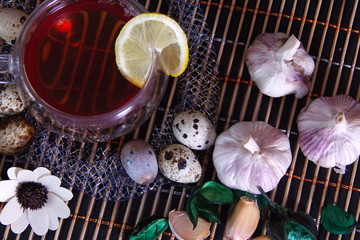 Healthy food, lemon tea, garlic, quail eggs photo for text advertising