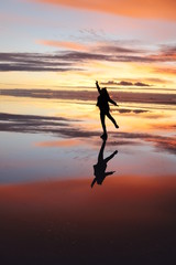 Dancing in the reflections of salt desert water, Bolivia