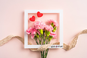 top view of carnation with card on pink background