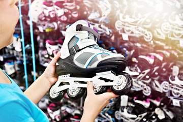 Woman chooses roller skates in shop