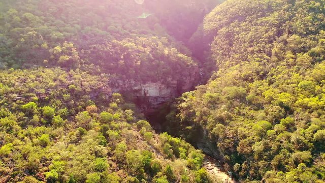 Aeirial of Rio Preto Canyon after Cachoeira do Riachinho Waterfall and environing caatinga vegetation landscape at Vale do Capao, Bahia, Brazil. Drone moving forward