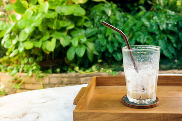 Empty coffee glass after drink on wood table green nature background