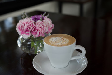 cup of coffee and flowers on table