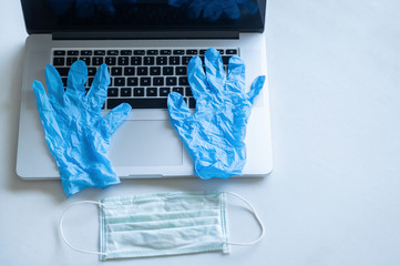 Pandemic work kit on white office desk with face mask and gloves. Corona virus covid-19 pandemic outbreak prevention
