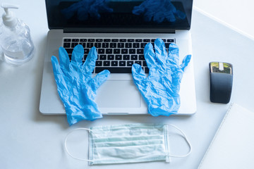 Pandemic work kit on white office desk with hand sanitizer, face mask and gloves. Corona virus covid-19 pandemic outbreak prevention