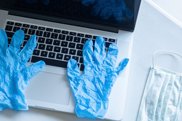 Pandemic work kit on white office desk with face mask and gloves. Corona virus covid-19 pandemic outbreak prevention