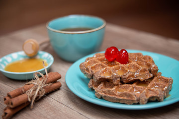 Healthy breakfast waffles with honey and coctail cherries