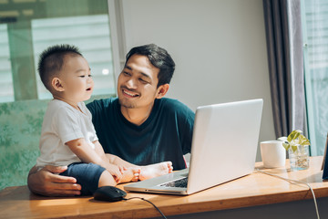 Father and little son happy family with laptop computer on workplace at office home happiness...