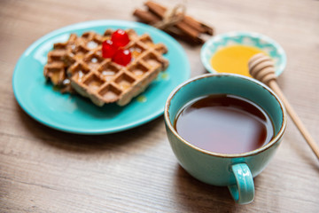 Healthy breakfast waffles with honey and coctail cherries