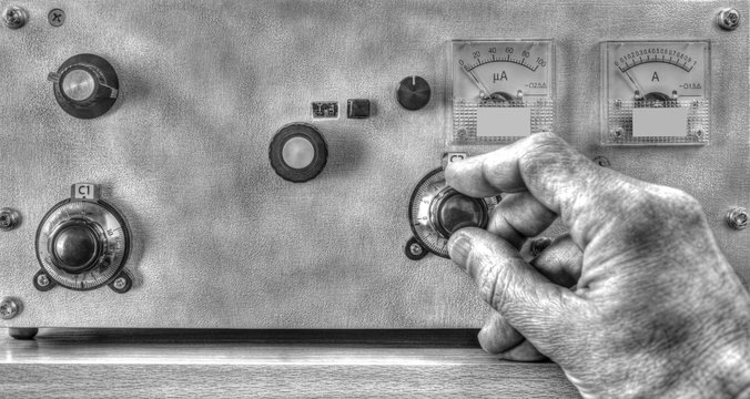 Close up view of radio amateur tuning the high frequency power amplifier in black and white