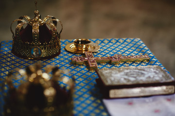 Orthodox golden wedding crowns, church icons, church books, gospel on the table. selective focus
