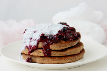 Pancakes with jam and cream on a white plate. Delicious homemade Breakfast.