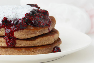 Pancakes with jam and cream on a white plate. Delicious homemade Breakfast.