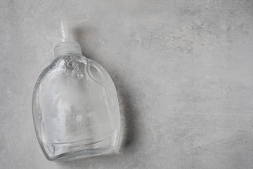 Envase de alcohol gel sobre mesa gris