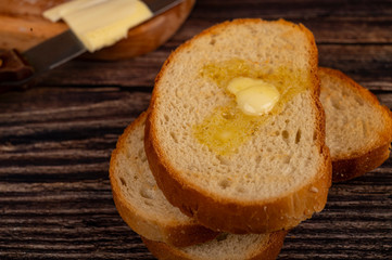 Fresh wheat toast with butter on a wooden background. Close up.