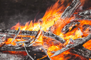 Bright flame through burning firewood.