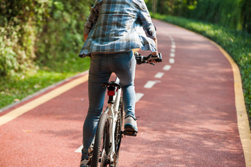 Naklejka premium Woman cyclist riding mountain bike in park