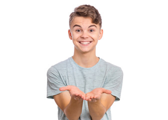 Portrait of cute smiling teen boy holding nothing. Happy teenager with empty palms up, isolated over white background. Child stretched out his hands - sign of begging or giving. - 334720796