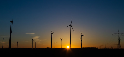Silhouette von Windr&auml;dern bei Sonnenuntergang