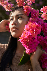 Naklejka premium Asian girl portrait face in pink flowers. Beautiful Balinese women. Beauty salon and massage spa concept