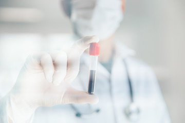 Doctor holding blood test. Pandemics outbreak crisis. Blood sample in a tube at lab. 