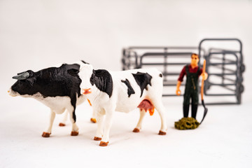 Toy farm. Miniature plastic cows and a worker.