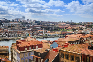 Fototapeta na wymiar Sweeping view over the city of Porto, Portugal with the Douro River and characteristic terra-cotta rooftops. 