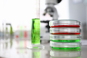 Close-up of laboratory glass containers and flask with colored liquid. Researching biotechnology...