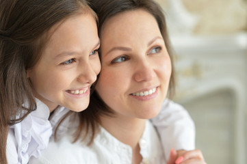 Beautiful young mother and cute little daughter posing