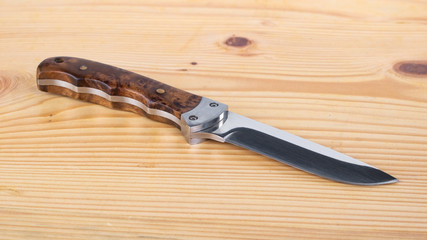 Beautiful hunting knife isolated on the wooden table