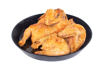 Homemade roasted chicken on the black iron pan isolated on white background