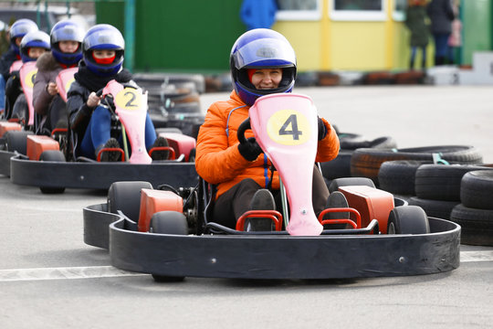 girl is driving Go-kart car with speed in a playground racing track.