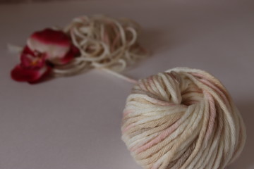 a  wool ball for knitting of light pale pink and beige colors