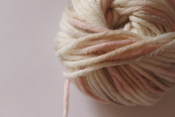 a  wool ball for knitting of light pale pink and beige colors