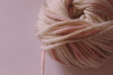 a  wool ball for knitting of light pale pink and beige colors