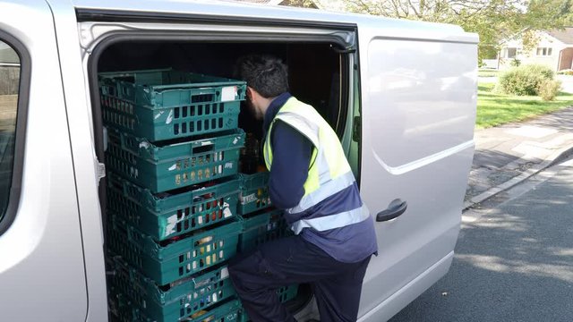 4K: Grocery delivery driver from Supermarket lifts crate of food out of the van - Online order. Stock Video Clip Footage