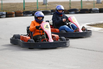 girl is driving Go-kart car with speed in a playground racing track.
